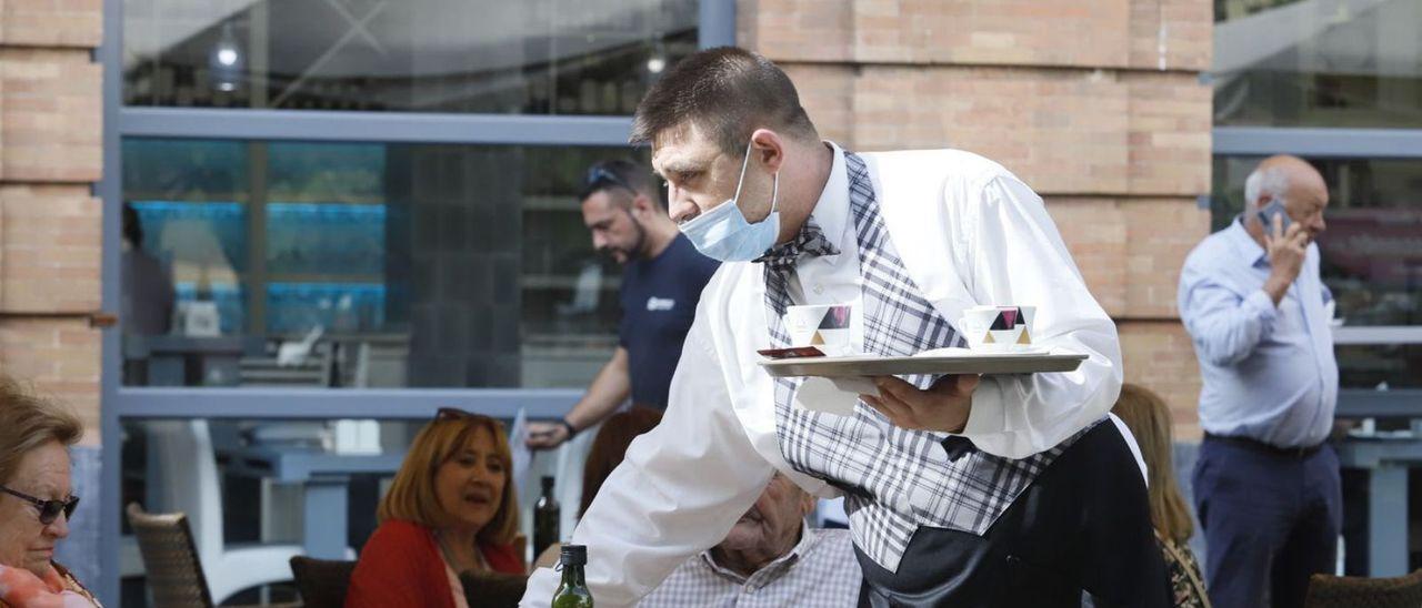 Un camarero sirve una mesa en un restaurante del centro de Córdoba.