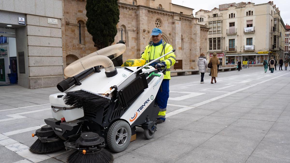 Un operario con una barredora eléctrica