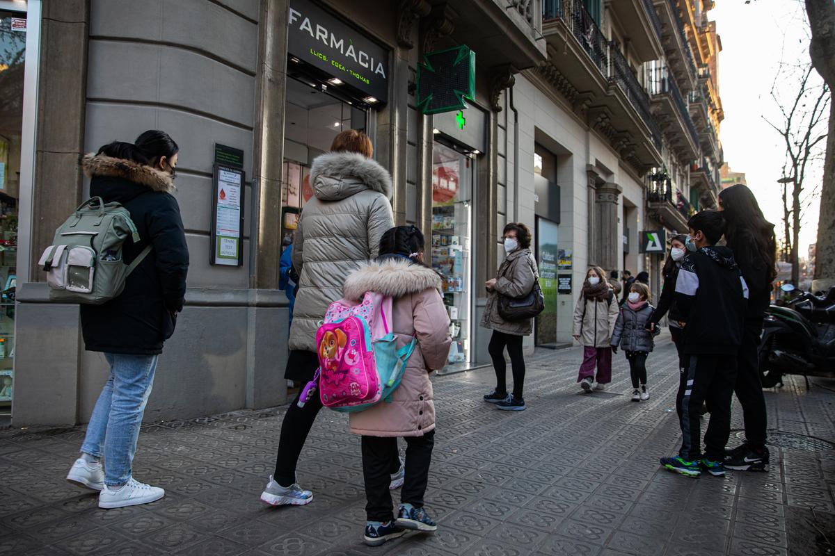 Varias personas esperan a la puerta de la farmacia Egea Thomas para los test de antígenos.