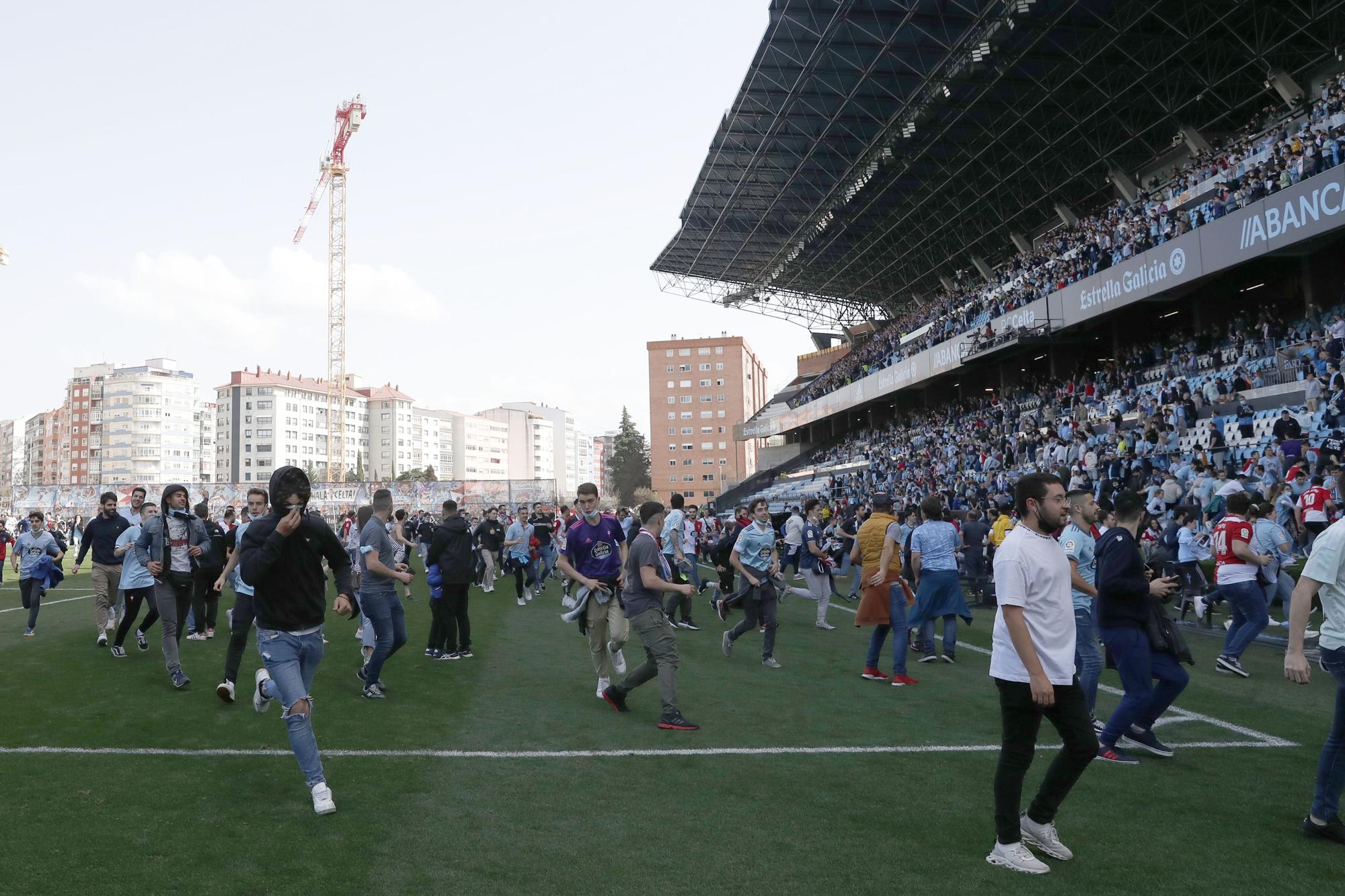 Aficionados del Celta escapan de la policía tras saltar al césped del estadio.