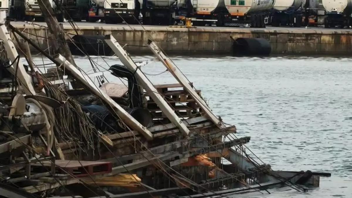 La batea destrozada tras el impacto de un buque en el puerto de València