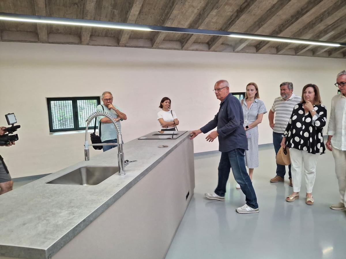 El alcalde empuja el mueble de los fogones y las clases de cocina