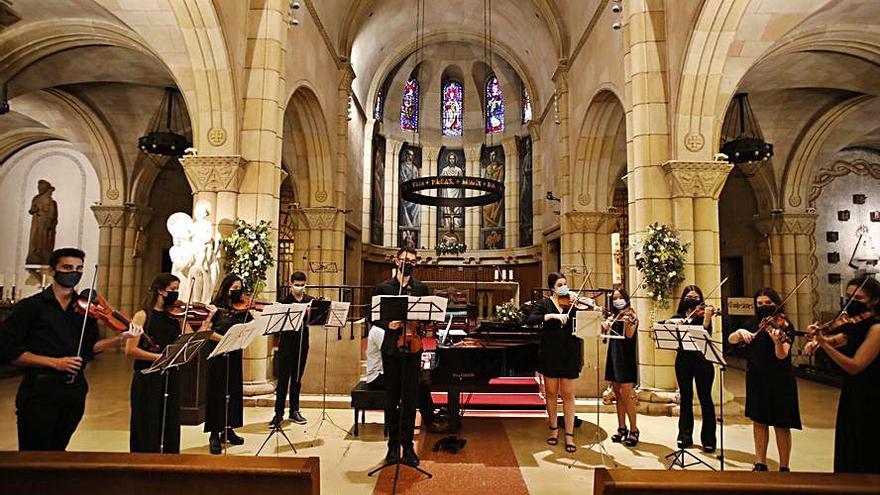 Los alumnos de la escuela Enrique Truan, tocando sus instrumentos, ayer, en la iglesia de San Pedro. | Ángel González