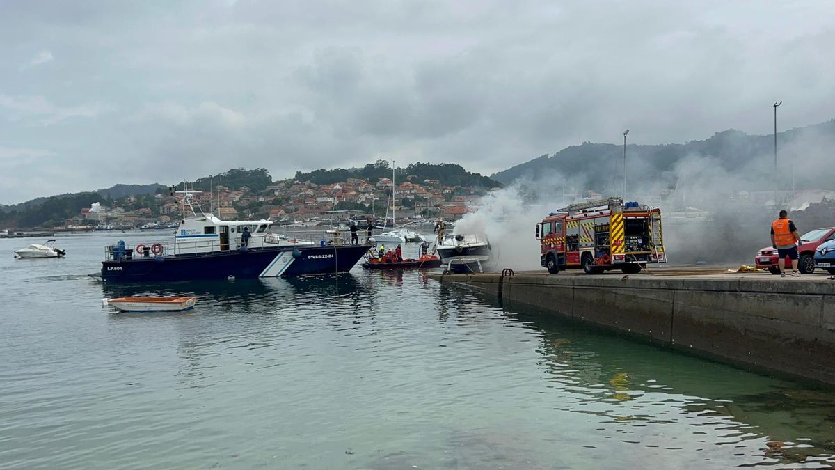Efectivos de extinción en el puerto de Vilariño sofocan las llamas de unas nasas y una embarcación.