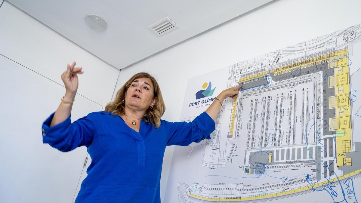 La directora del Port Olimpic, Olga Cerezo, muestra la distribución de los nuevos locales de economía azul que se comercializan en el recién renovado Moll de Mestral.