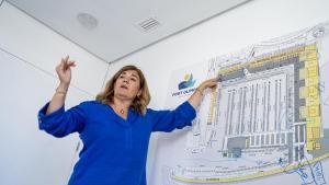 La directora del Port Olimpic, Olga Cerezo, muestra la distribución de los nuevos locales de economía azul que se comercializan en el recién renovado Moll de Mestral.