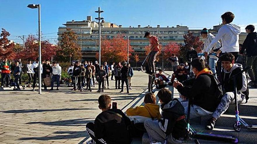 Un patinador fent un salt davant la mirada d&#039;altres joves.