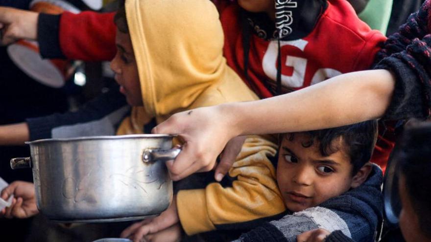 Nens palestins esperen perrebre menjar en una cuinabenèfica, a Rafah, Gaza. | M. SALEM / REUTERS