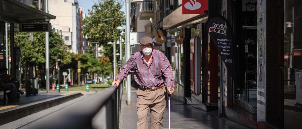 Un hombre pasea por el centro de Santa Cruz de Tenerife con su bastón.