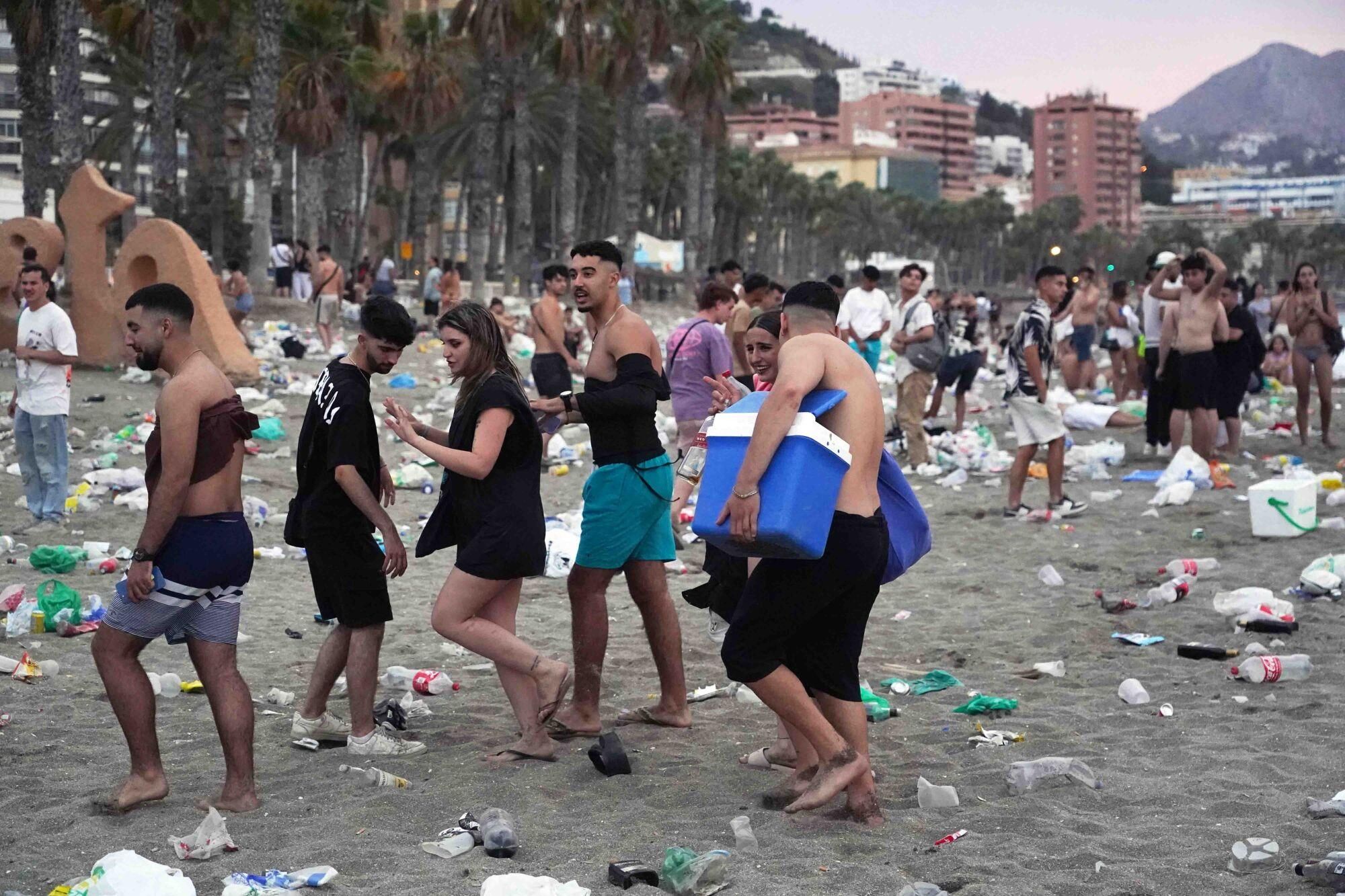 Varios operarios de la empresa de limpieza de Limasam, recogen los residuos de la playa de La Malagueta, tras la Noche de San Juan en Málaga 2025