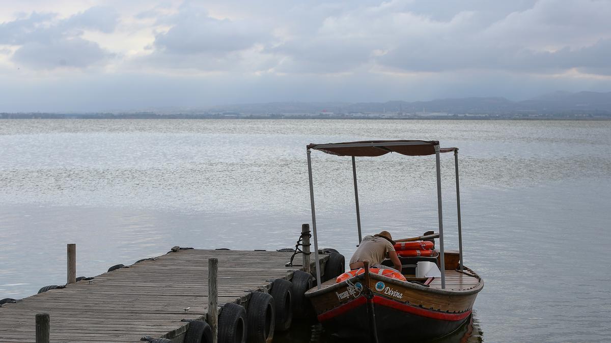 Un tripulante espera en su barca atracada en el embarcadero del Parque Natural de La Albufera en las inmediaciones de la localidad de El Palmar, en Valencia