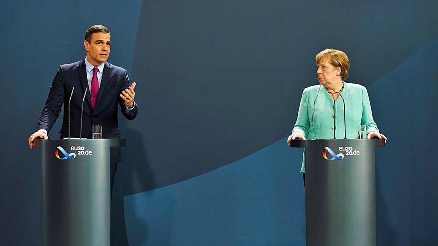 Merkel escolta Sánchez, que intervé en la compareixença conjunta.