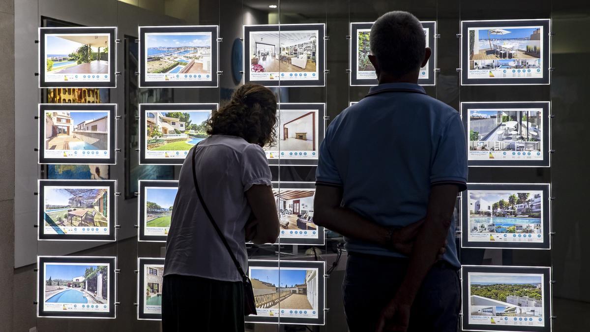 Una persona frente a una inmobiliaria.