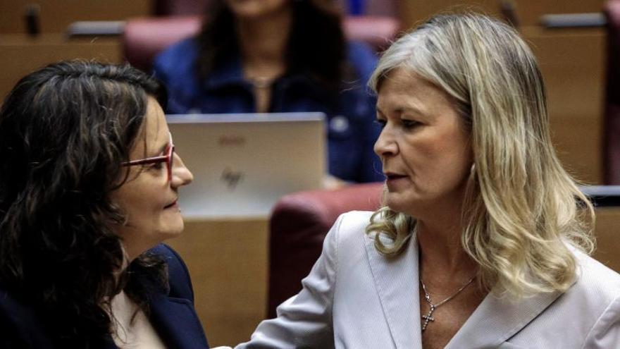 La vicepresidenta Oltra conversa con la consellera de Justicia, Gabriela Bravo, en un pleno de las Corts.