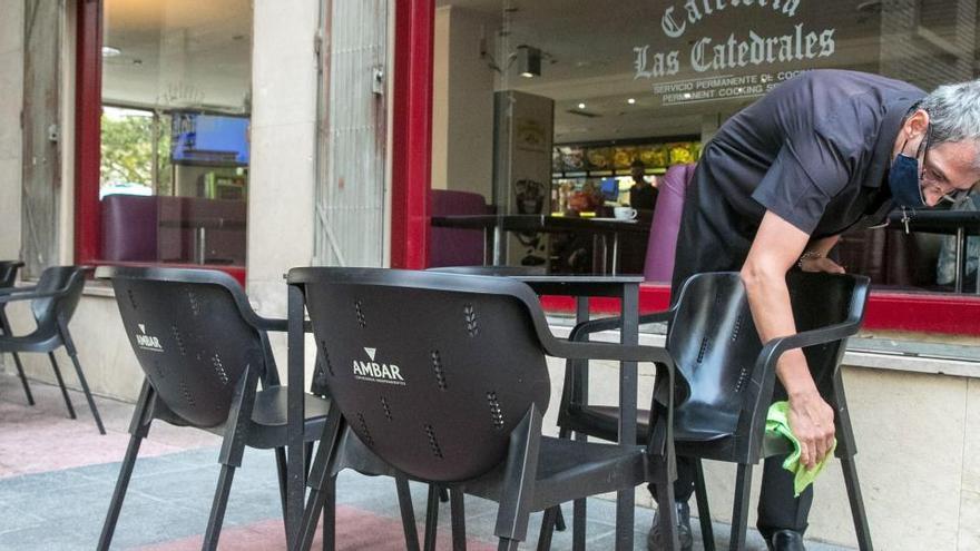 Un hostelero desinfecta el mobiliario de la terraza