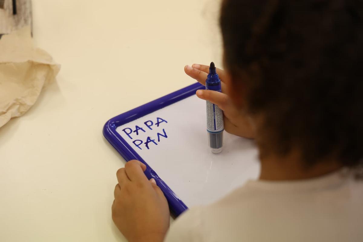 Un niño escribiendo palabras que empiezan con la letra P.