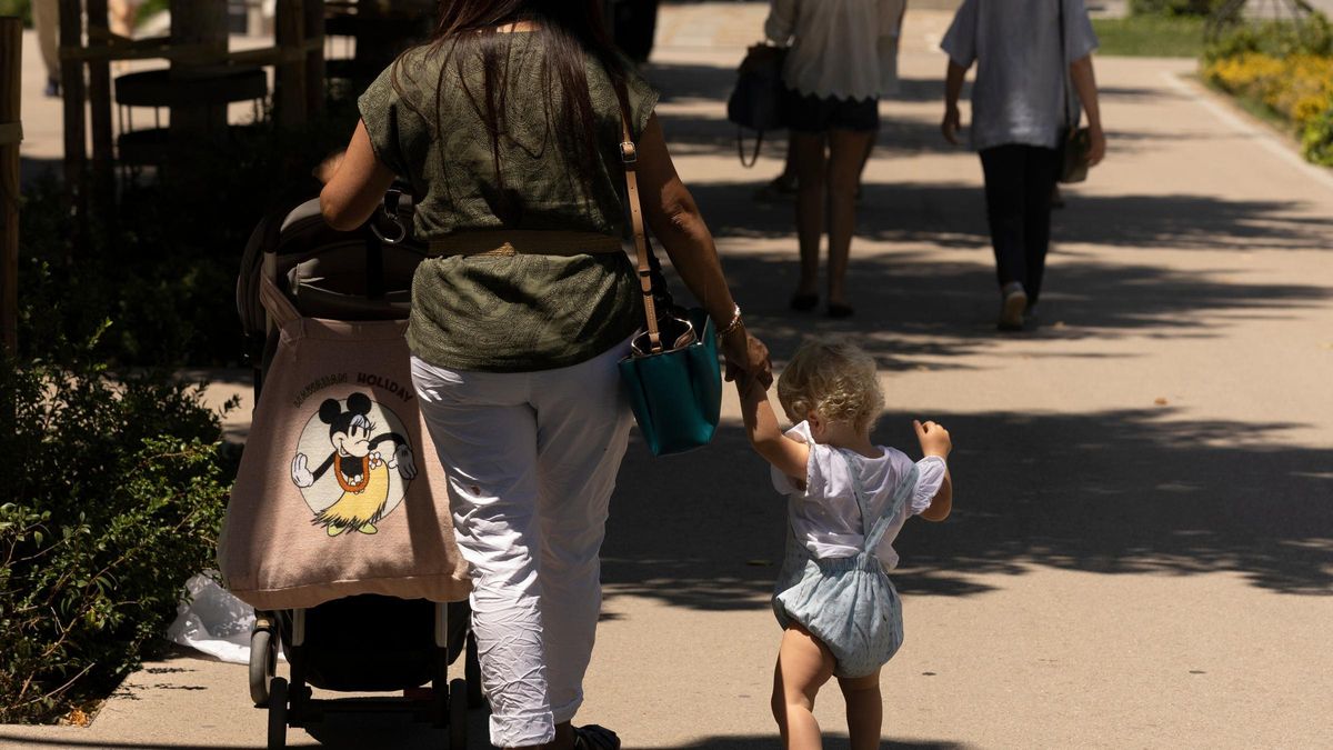 Una mujer pasea con su hijo y un cochecito de bebé, en Madrid.