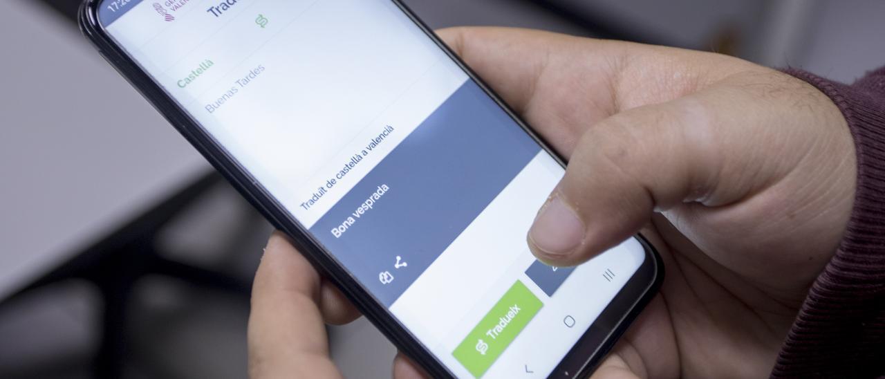 Un usuario consulta una app móvil de traducción al valenciano.