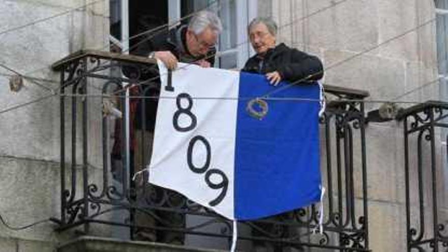 Dos vecinos ambientando, ayer, sus balcones en el Casco Vello. // Ricardo Grobas