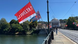 El puente Vittorio Emanuele I sobre el río Po con banderas alusivas a la Vuelta, en Turín.