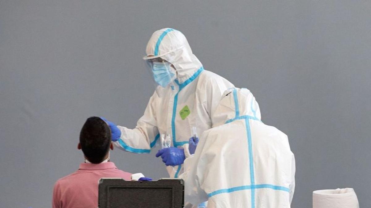 Dos sanitarios practican una prueba para detectar el covid.