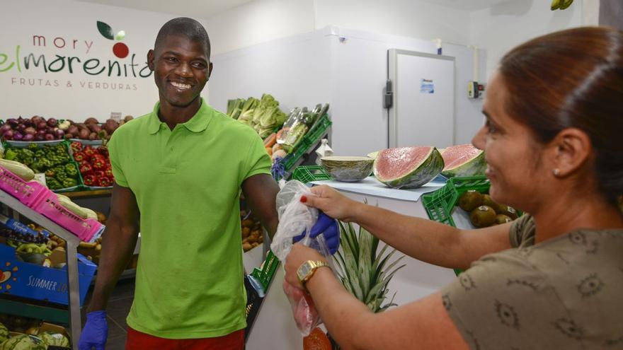 Un autónomo extranjero en su negocio de frutas y verduras.