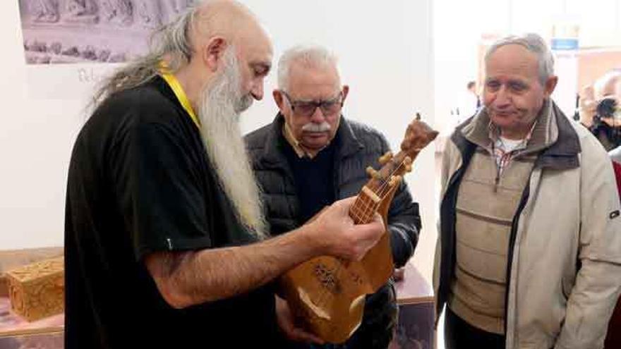 Jesús Reolid (primero por la izquierda) muestra a dos hombres uno de los instrumentos.