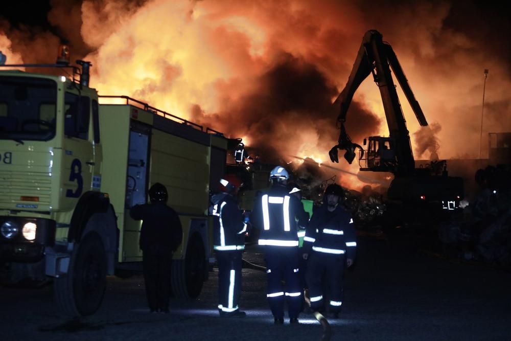 Labores de extinción del incendio de un desguace en Gijón