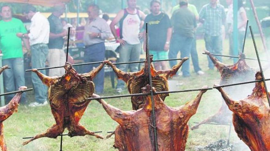 Los corderos ensartados en las estacas asándose, en las fiestas de Puerto.