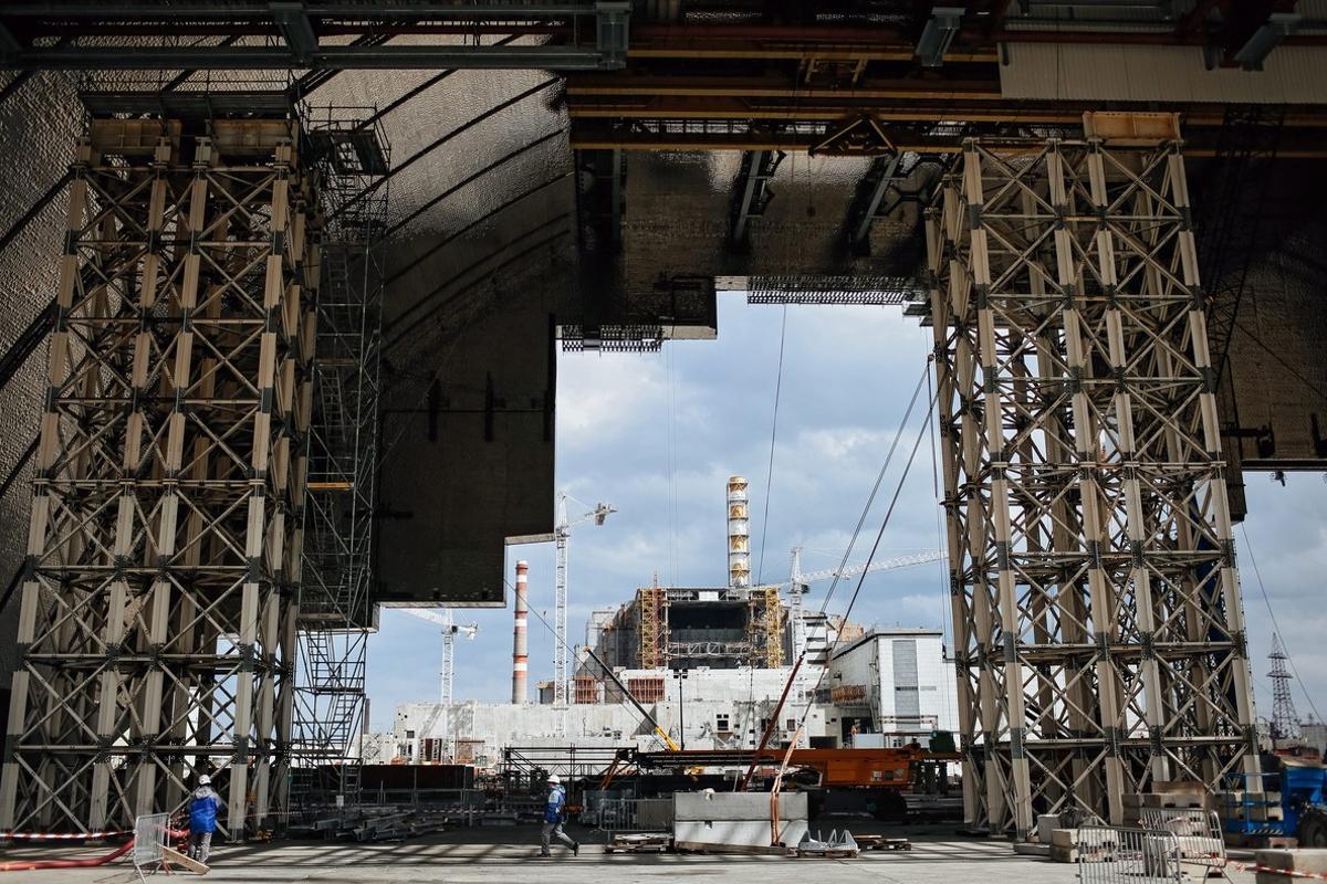 RPI02. Chernobyl (Ukraine), 22/04/2016.- Visitors and journalists look at the Chernobyl nuclear power plant which is seen through the construction of a new protective shelter which will be placed over the remains of the nuclear reactor Unit 4, at Chernobyl nuclear power plant, in Chernobyl, Ukraine, 22 April 2016. Construction works for a new protective shelter which will be mounted over the old one are currently underway at the site near. The explosion of Unit 4 of the Chernobyl nuclear power plant in the early hours of 26 April 1986 is still regarded the biggest accident in the history of nuclear power generation. Ukrainians will mark the 30th anniversary of Chernobyl’s tragedy on 26 April 2016. (Ucrania) EFE/EPA/ROMAN PILIPEY