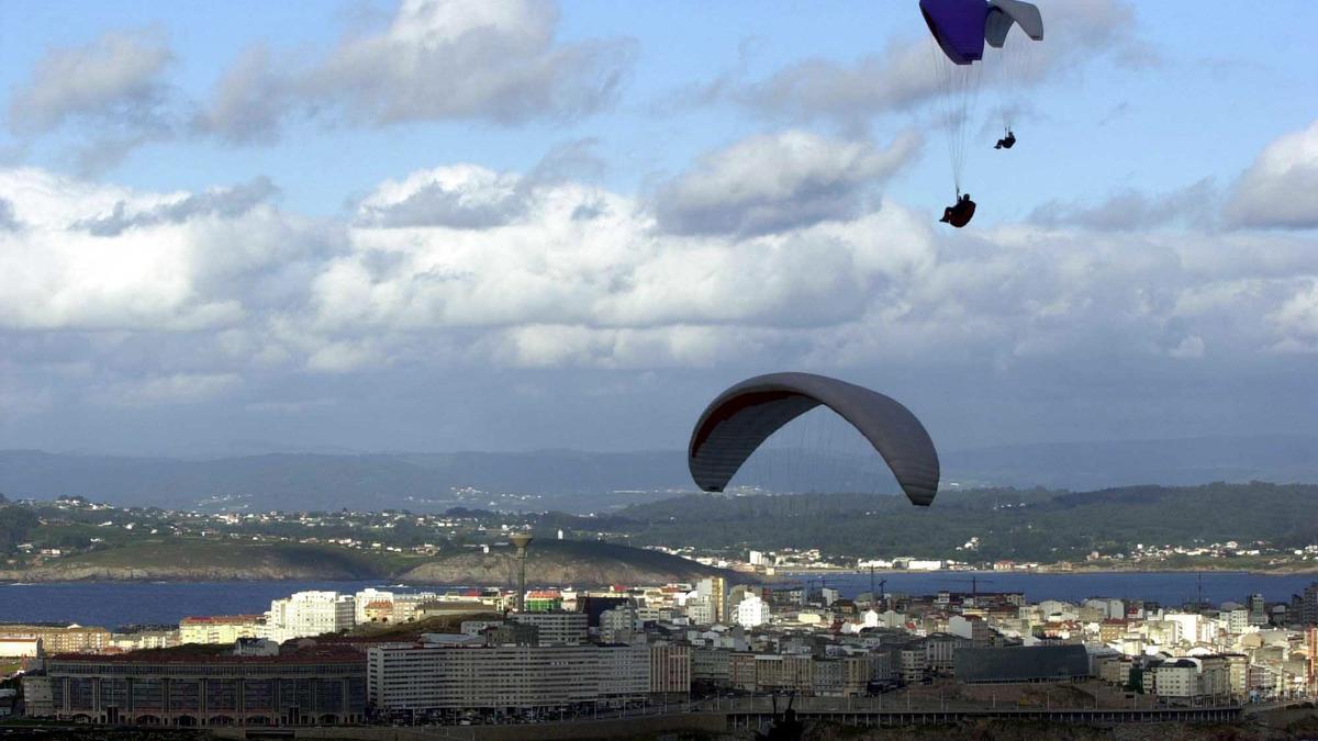 Un parapente al vuelo en A Coruña un día con algunas nubes.