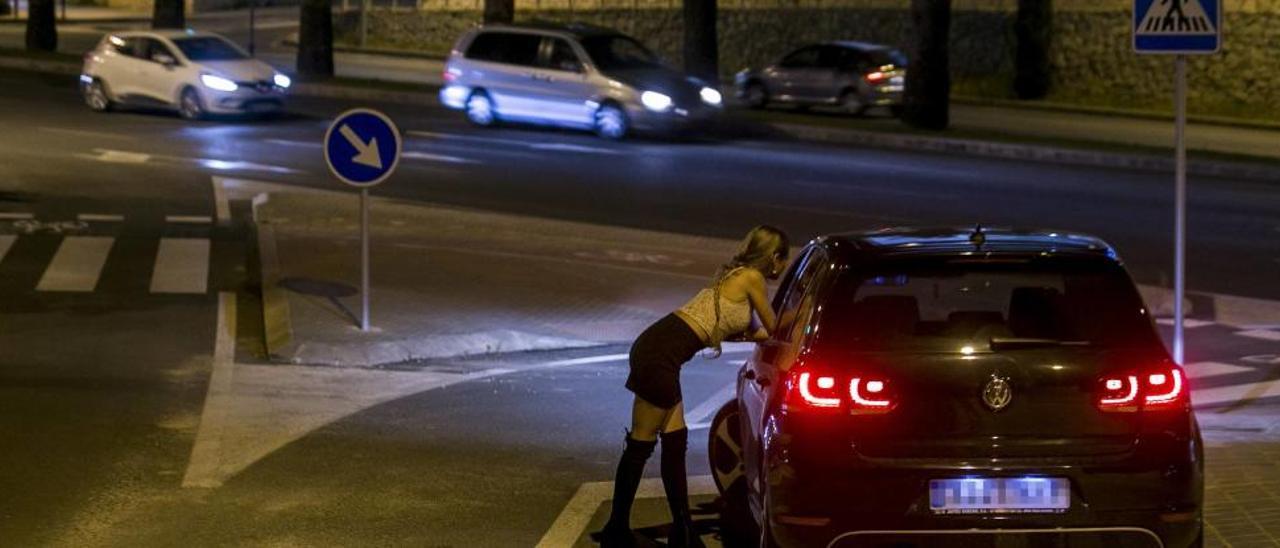 Una prostituta se acerca a un coche en las inmediaciones a la avenida de Dénia. |
