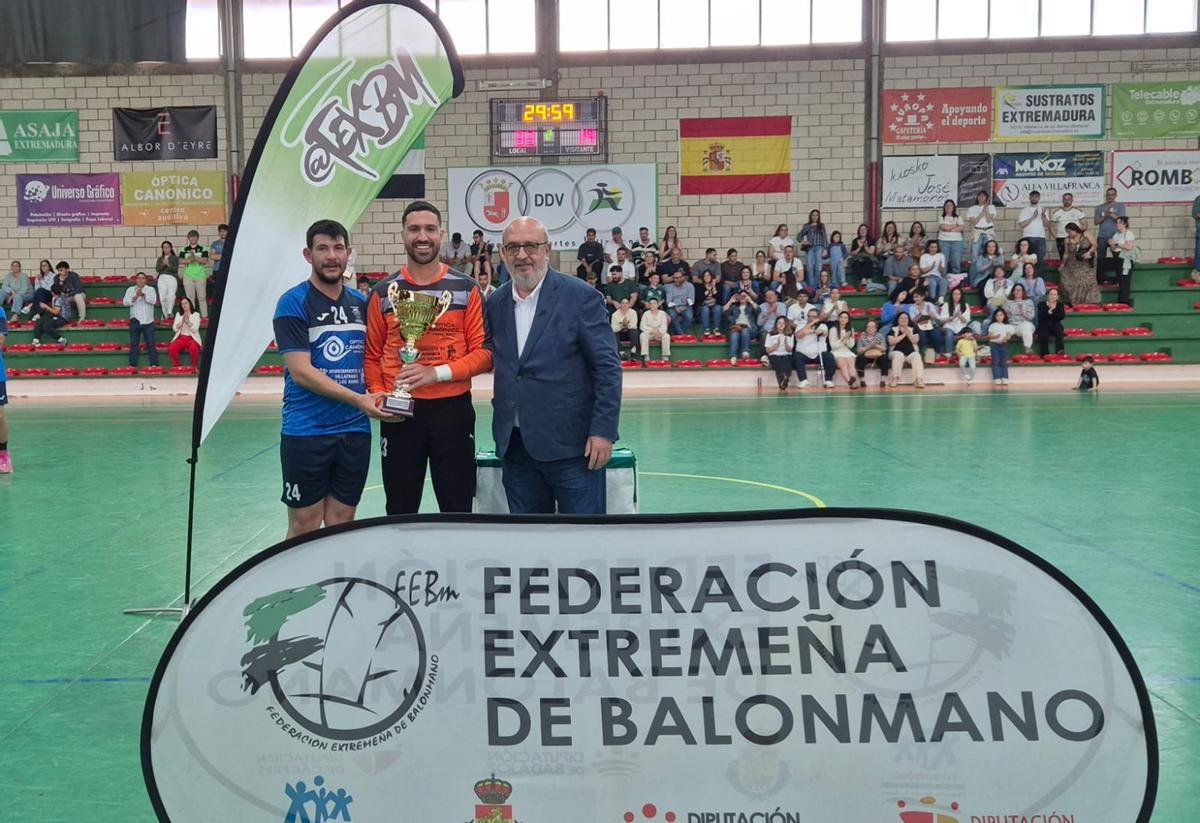 El Ciudad de Villafranca recibe el trofeo de campeón de manos del presidente de la Federación Extremeña de Balonmano.