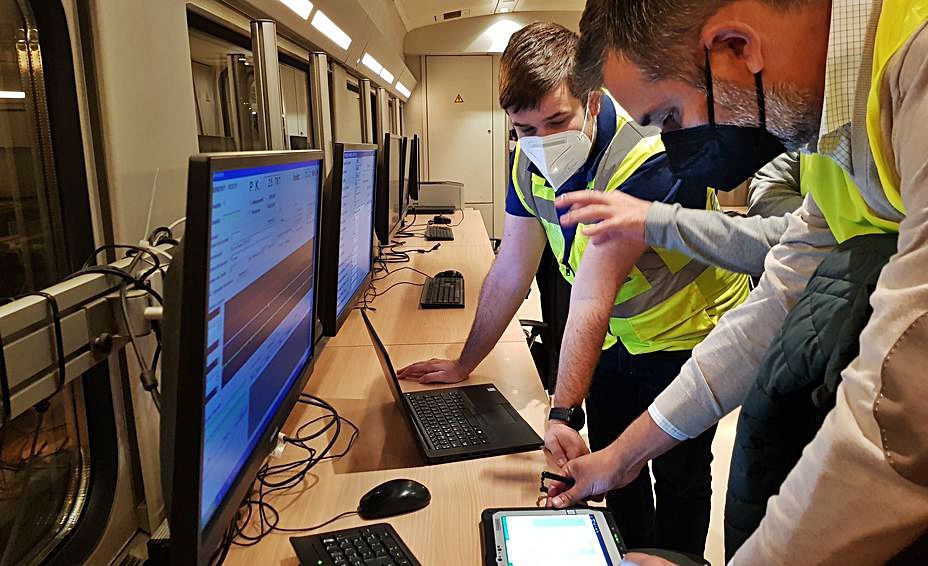 Dos técnicos de Adif, comprobando en los ordenadores las mediciones del tren laboratorio. | Ramón Díaz