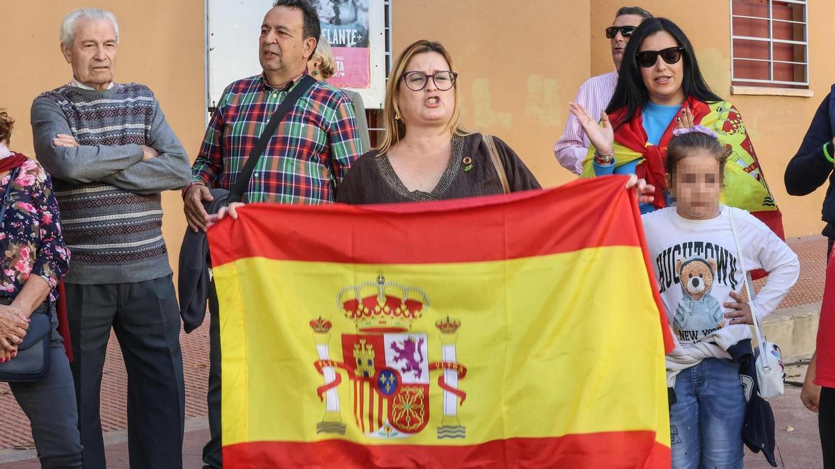 La concejala de Vox de Callosa de Segura, responsable del área de Servicios Sociales, Rosario Griñán, frente la sede de Vox. En la protesta también han participado menores