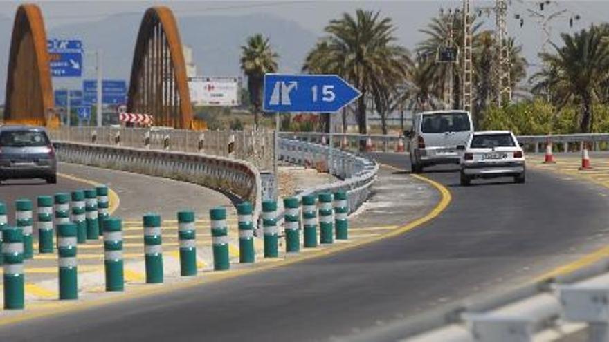 Unos vehículos circulan, ayer, en dirección al nuevo puente sobre el Carraixet que mantendrá su color óxido.