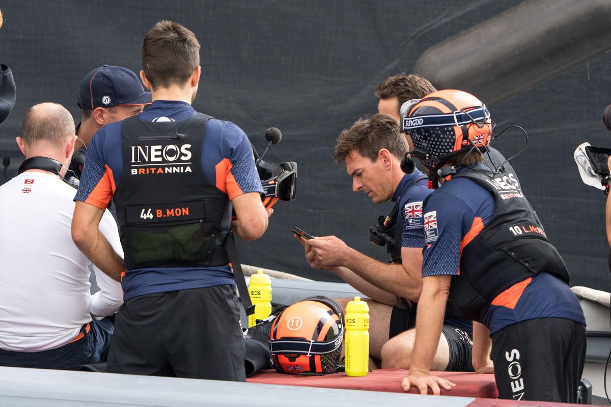 El timonel del Ineos, Dylan Fletcher (en el centro), consulta unos datos a bordo de uno de los barcos de acompañamiento, este lunes.