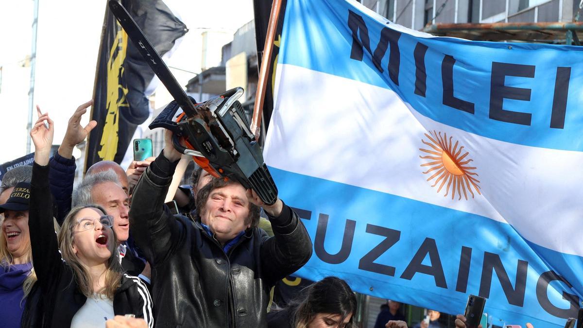 El candidato a presidente de Argentina, Javier Milei, hace campaña con una motosierra entre una multitud.