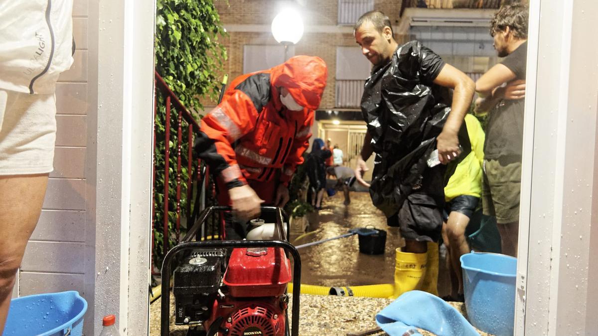 Los bomberos durante los trabajos de achique de agua que siguen activos en Benicàssim.