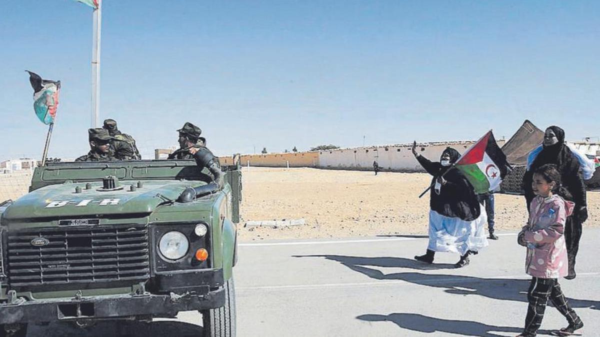 Refugiados saharauis de los campamenos de Tinduf junto a un vehículo militar del Frente Polisario.