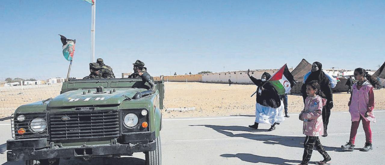 Refugiados saharauis de los campamenos de Tinduf junto a un vehículo militar del Frente Polisario.