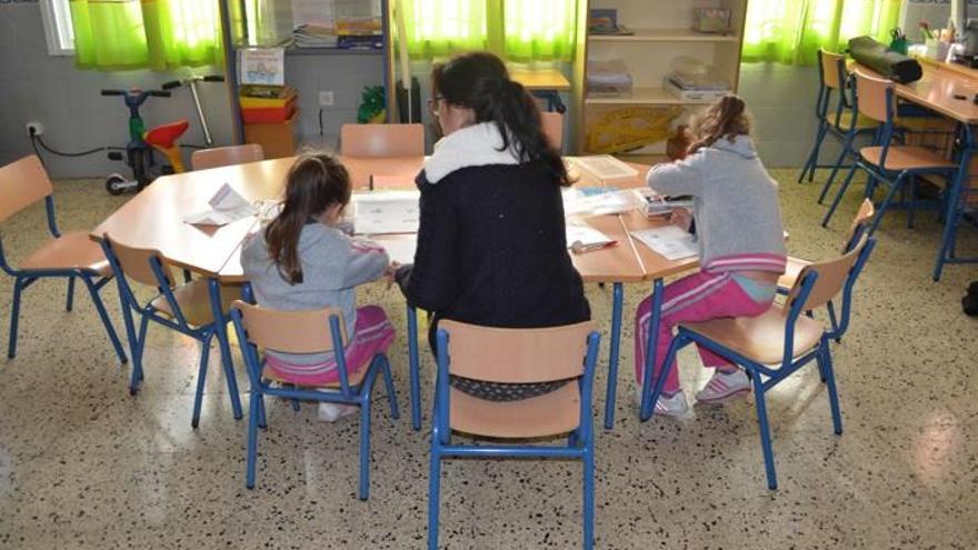 Imagen de la maestra con dos de las alumnas en el colegio de Cartajima.