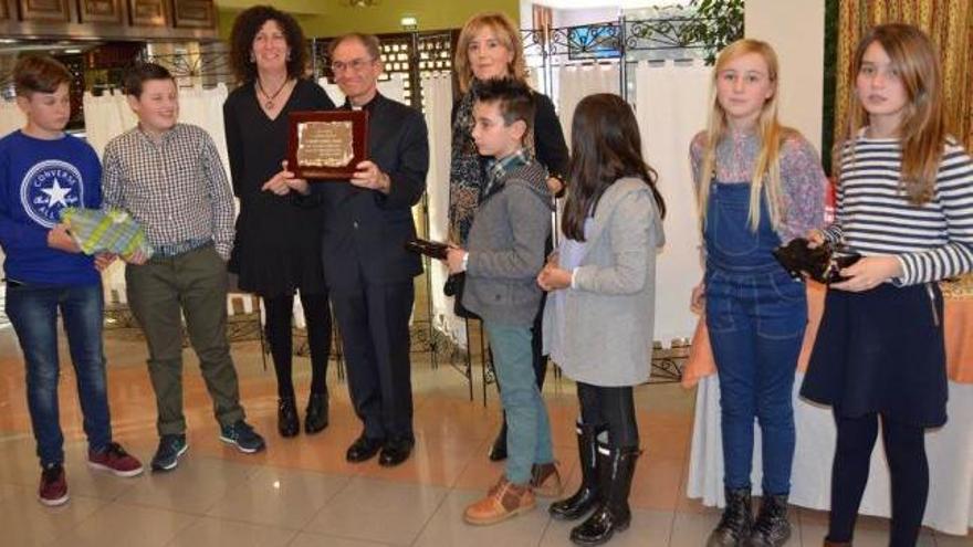 Jesús Domingo García Valle, en el centro, muestra una placa conmemorativa del homenaje, rodeado por feligreses.