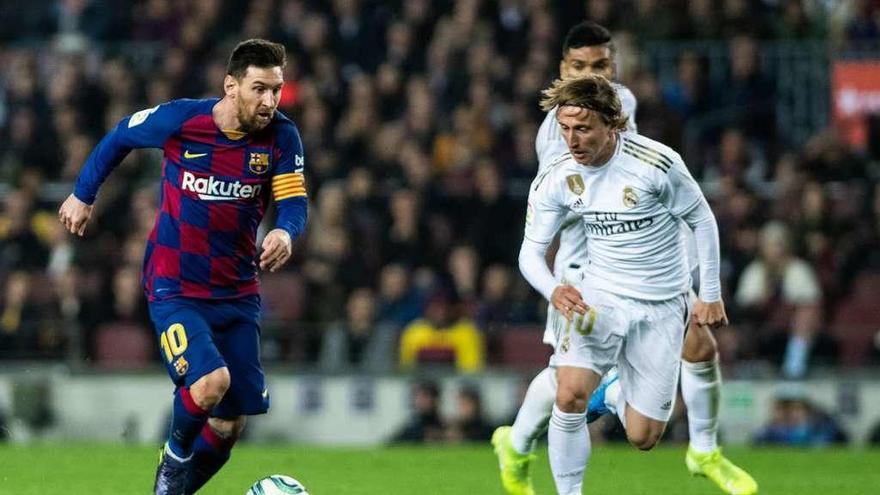 Messi y Modric corren por un balón en un Barcelona-Real Madrid. // Efe