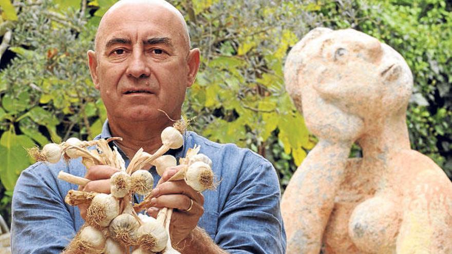 El artista Joan Bennàssar, con varias cabezas de ajos.