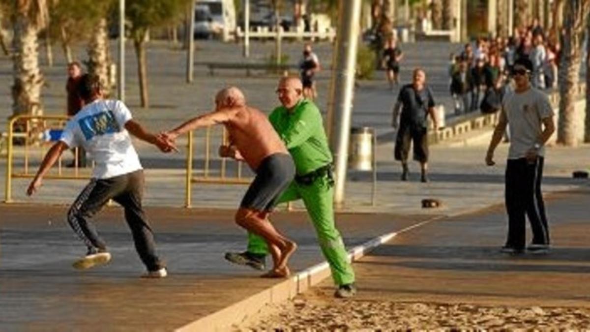 Un hombre agarra del brazo a un carterista que le ha robado sus pertenencias en la playa de la Barceloneta, el 30 de octubre.