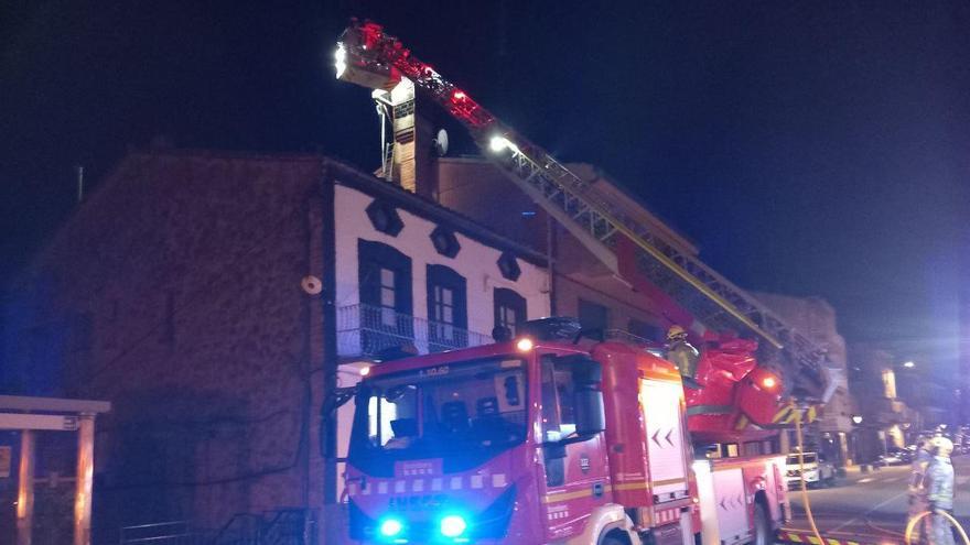 Bombers, treballant en l'extinció del foc en una xemeneia d'un edifici de Puig-reig