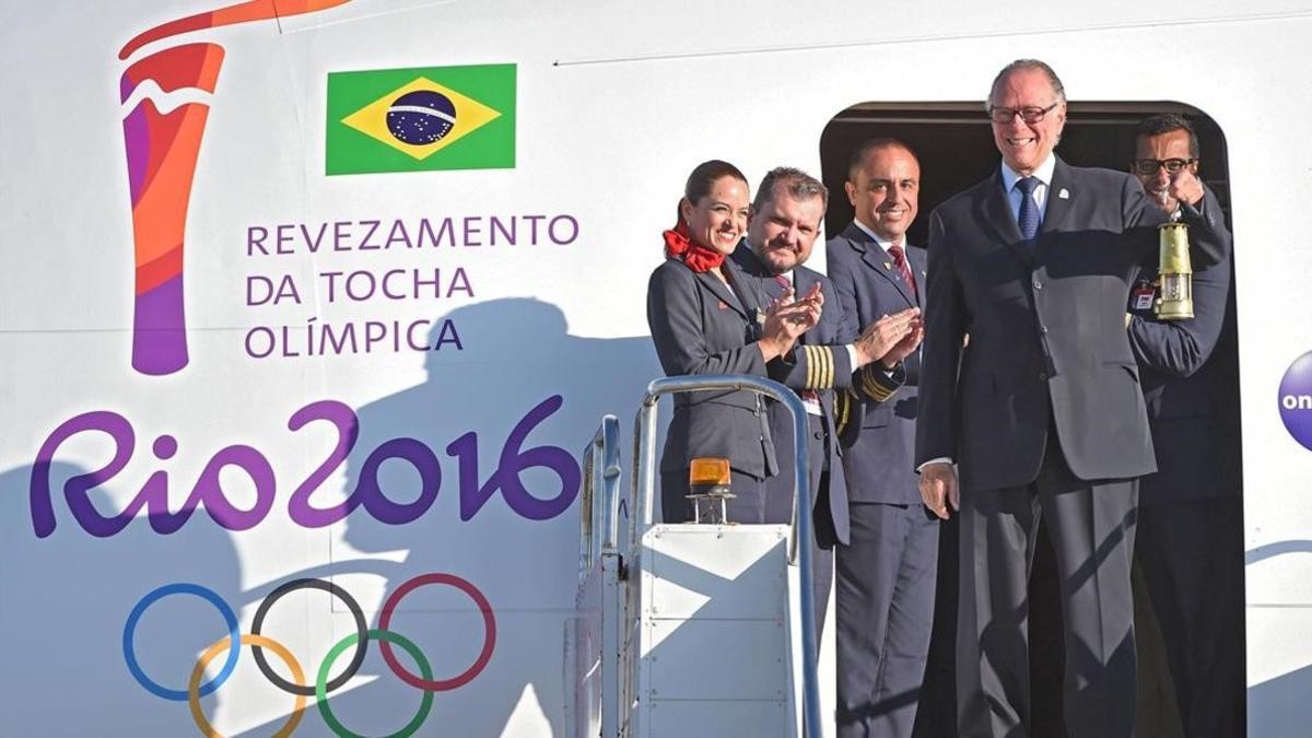 El presidente del Comite Olímpico Brasileño, Carlos Arthur Nuzman, transporta la linterna con el fuego olímpico a su llegada a Brasilia.