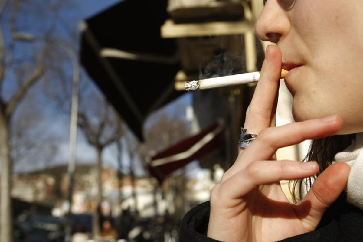 Una dona fuma al carrer, després de l’aplicació de la llei contra el tabac, en una imatge del 2011.