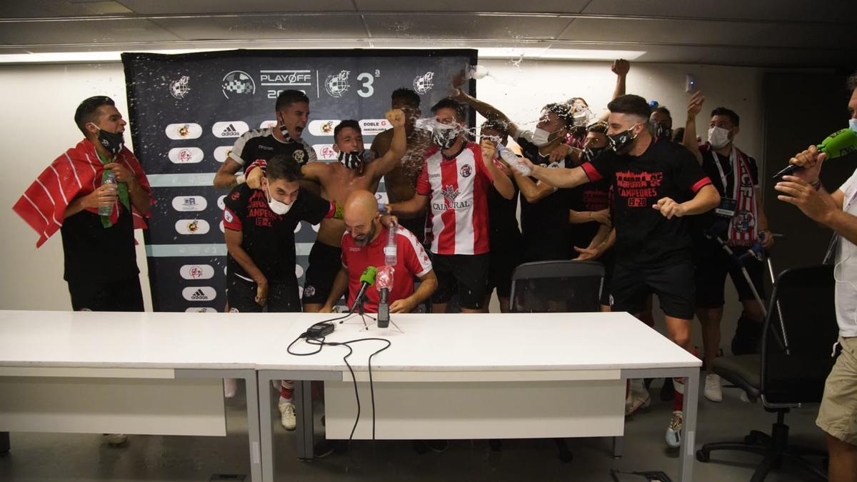 David Movilla es regado con champán por sus jugadores del Zamora CF durante la rueda de prensa tras el ascenso a Segunda B.